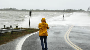 Una dona fa fotografies de les onades que creuen una carretera a Southampton, Nova York/ REUTERS/ Lucas Jackson