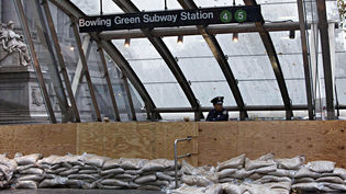 Un oficial de la Policia de Nova York vigila una entrada de metro tancada a mode de prevenció de l'arribada de l'huracà Sandy al centre de Manhattan. Nova York/ REUTERS/ Andrew Kelly