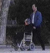 Imatge d'un home passejant un senyor gran en cadira de rodes